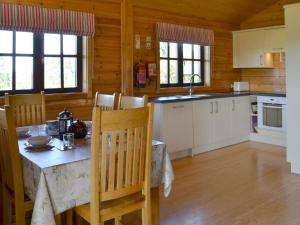 a kitchen with a table and chairs in a cabin at Otter - Uk12540 in Witheridge