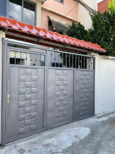een grijze garagedeur met een poort voor een gebouw bij Royal House in Elbasan