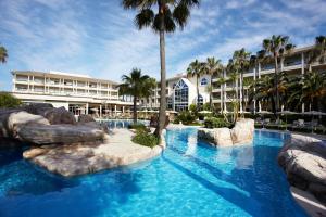een resort met een zwembad met een glijbaan bij Grupotel Parc Natural & Spa in Playa de Muro