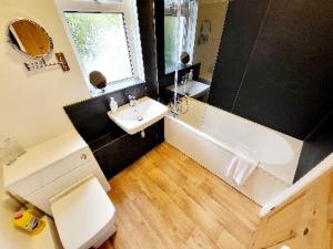 a bathroom with a tub and a sink and a toilet at 8 Duke Street - Launceston Cornwall in Launceston