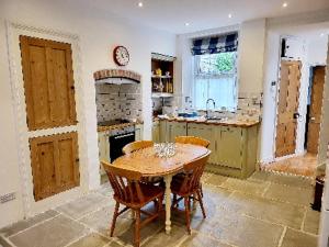 a kitchen with a table and a stove in it at 8 Duke Street - Launceston Cornwall in Launceston