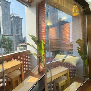 a balcony with two wooden tables and a window at Eco nest in Hanoi