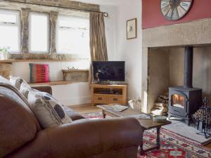a living room with a couch and a fireplace at Club House in Hebden Bridge