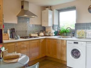 a kitchen with a washing machine and a sink at Club House in Hebden Bridge