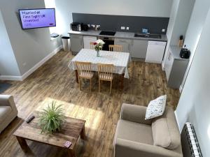 a living room with a table and a kitchen at Galloway Farmstay Claunch in Newton Stewart