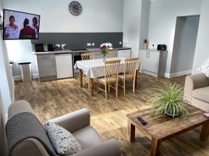 a living room with a table and chairs and a kitchen at Galloway Farmstay Claunch in Newton Stewart