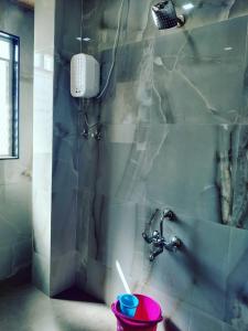 La salle de bains est pourvue d'un robinet et d'un seau d'eau. dans l'établissement Shiv- Vatsalya Homestay, à Nashik