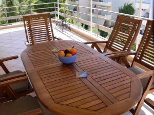 einen Holztisch mit einer Obstschale darauf in der Unterkunft Breezy Veranda Apartment Varkiza in Vari