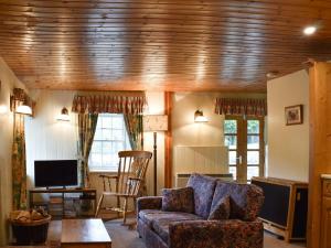 a living room with a couch and a tv at Burnmouth in Balnaboth