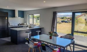 a kitchen with a table and chairs and a large window at Rough Ridge Cottage ~ your haven in Central Otago in Oturehua