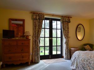 a bedroom with a bed and a sliding glass door at The Old School Penallt in Mitchel Troy