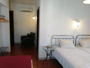 een slaapkamer met een bed, een stoel en een tafel bij Casa Monreal in Reguengos de Monsaraz