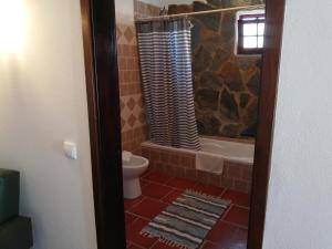 een badkamer met een bad, een toilet en een douche bij Casa Monreal in Reguengos de Monsaraz