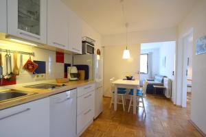 a kitchen with white cabinets and a table with chairs at Apartments Cordasev in Vantačići