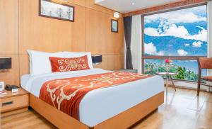 a bedroom with a large bed and a window at Summit Swiss Heritage Resort & Spa in Darjeeling
