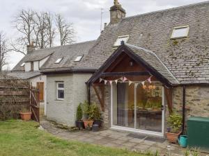 a house with an awning over a patio at Smiddy Cottage in Aberfeldy