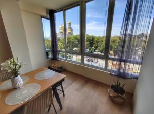 a dining room with a table and a large window at By The Cathedral, 1 bed flat in Varna City