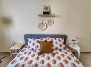 - une chambre avec un lit aux points polka roses et blancs dans l'établissement By The Cathedral, 1 bed flat, à Varna