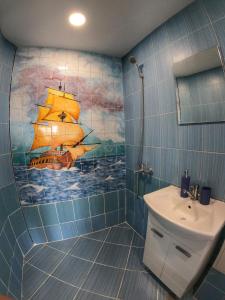 a bathroom with a painting of a sailboat on the wall at By The Cathedral, 1 bed flat in Varna City