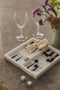 a tray with dice and wine glasses and flowers on a table at The More Hotel Västra Hamnen in Malmö