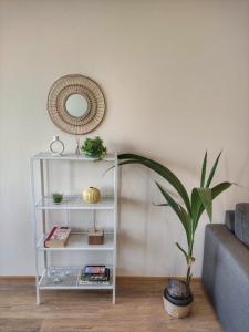 - une étagère blanche avec un miroir et une plante dans le salon dans l'établissement By The Cathedral, 1 bed flat, à Varna