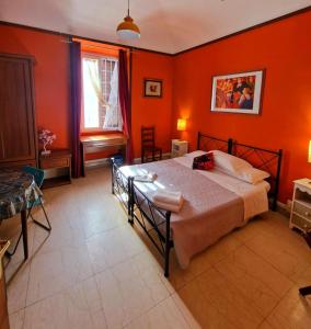 ein Schlafzimmer mit orangefarbenen Wänden und einem großen Bett in der Unterkunft Casa Totti in Rom