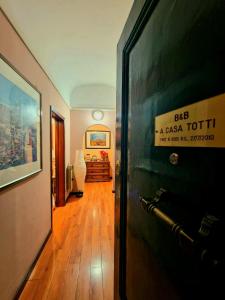 Un pasillo con una puerta con un cartel. en Casa Totti, en Roma