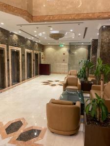 a lobby with couches and plants in a building at Plaza Inn Ohud Hotel in Al Madinah