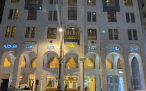 Plaza Inn Ohud Hotel في المدينة المنورة: مبنى كبير عليه لافتات