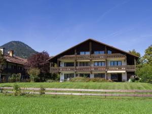 a large wooden house with a green field in front of it at Ferienwohnung Panoramablick in Oberaudorf