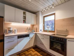 a kitchen with white cabinets and a window at Ferienwohnung Panoramablick in Oberaudorf
