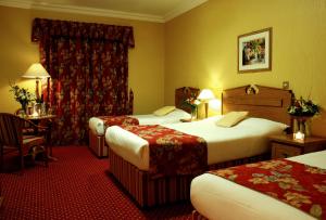 
a hotel room with two beds and two lamps at Clonakilty Park Hotel in Clonakilty

