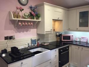 a kitchen with a sink and a microwave at Sunrise Cottage in Linton