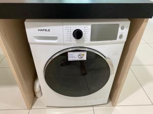 a white washing machine sitting under a counter at KK City Sutera Avenue Opposite Imago by JR Homestay in Kota Kinabalu