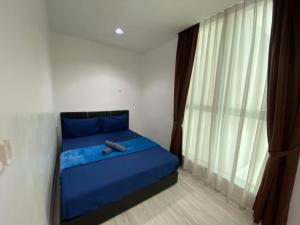 a bedroom with a blue bed and a window at KK City Sutera Avenue Opposite Imago by JR Homestay in Kota Kinabalu