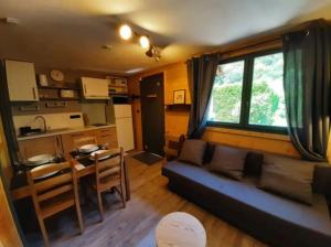 a living room with a couch and a table and a kitchen at O COSY D'OLLE in Allemont