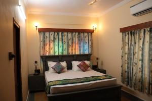 sypialnia z łóżkiem z zagłówkiem i zasłonami w obiekcie BALARWA HAVELI w mieście Dźodhpur