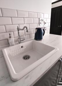 a white kitchen sink with a tea kettle on it at The Vault - boutique apartment in the centre of King's Lynn in Kings Lynn