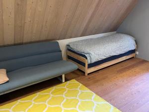 Habitación con cama, sofá y alfombra. en Luxe tuinhuis nabij Amsterdam, en Oostzaan