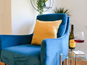 een blauwe stoel met een kussen en een glas wijn bij 3 Old Posting Stables in Gatehouse of Fleet