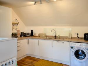 a kitchen with a sink and a washing machine at 3 Old Posting Stables in Gatehouse of Fleet