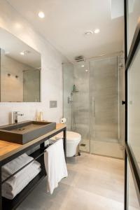 a bathroom with a sink and a shower at Kyrat Amarac Suites in Cala Millor