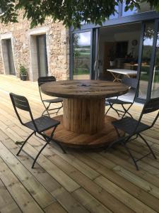 une table et des chaises en bois sur une terrasse en bois dans l'établissement Chambre spacieuse Le clos des vignes, à Chavanay