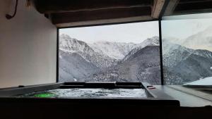 a bath tub with a view of a mountain range at Chalet Cormignano in Vezza dʼOglio