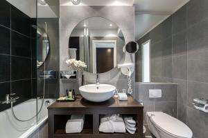 a bathroom with a sink and a toilet and a mirror at Jade Manotel in Geneva