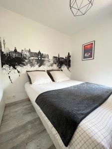 a bedroom with a bed with a black and white blanket at Le Roazhon, Rennes métropole in Rennes