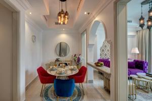 a dining room with a table and red chairs at Durrani Homes - Heaven on Earth in Dubai