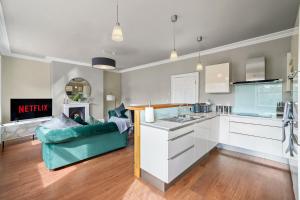 a kitchen with white cabinets and a green couch in a room at The Exclusive House in Yorkshire - Garden -Parking in Wakefield