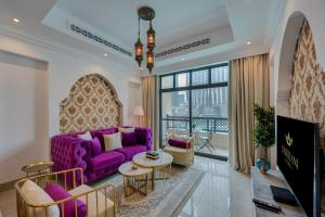een woonkamer met een paarse bank en een tafel bij Durrani Homes - Heaven on Earth in Dubai
