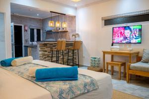 a bedroom with a large bed and a kitchen at Treasure Villa in Anse Possession